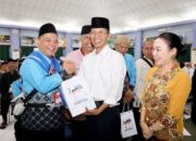 Wali Kota Batam, Amsakar Achmad, bersama Wakil Wali Kota Batam, Li Claudia Chandra, menyerahkan bingkisan kepada JCH Batam di Asrama Haji Batamcentre, Selasa (21/4/2026).