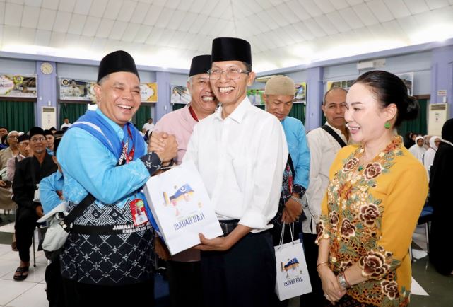 Wali Kota Batam, Amsakar Achmad, bersama Wakil Wali Kota Batam, Li Claudia Chandra, menyerahkan bingkisan kepada JCH Batam di Asrama Haji Batamcentre, Selasa (21/4/2026).