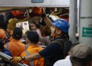 Petugas mengevakuasi korban yang masih terjebak di dalam gerbong KRL Commuterline yang bertabrakan dengan KA Argo Bromo Anggrek di Stasiun Bekasi Timur, Bekasi,