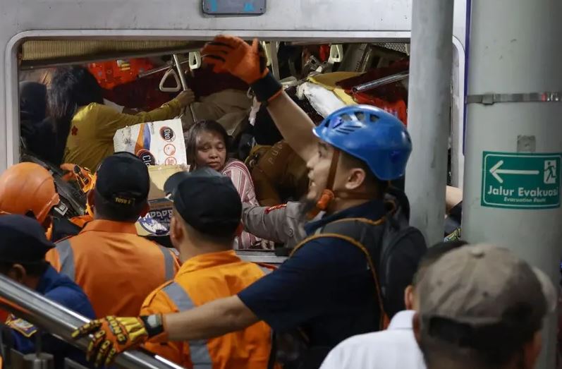 Petugas mengevakuasi korban yang masih terjebak di dalam gerbong KRL Commuterline yang bertabrakan dengan KA Argo Bromo Anggrek di Stasiun Bekasi Timur, Bekasi,