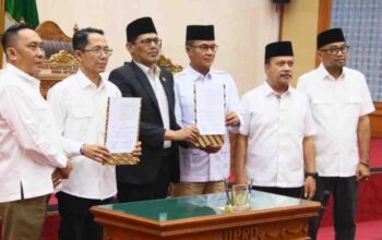 Ketua DPRD Batam Kamaluddin dan Wali Kota Amsakar Achmad menandatangani dokumen pengesahan Perda Adminduk di ruang sidang utama.