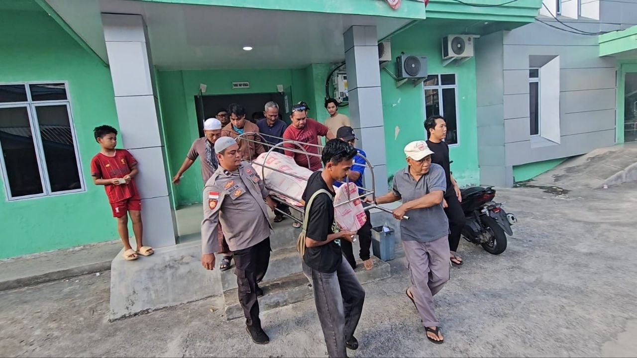 Aipda Raja Faisal Mushawir mengenakan seragam polisi saat bersiap mengemudikan mobil jenazah untuk melayani warga di Kepulauan Anambas