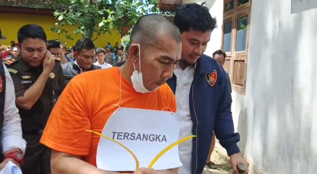 Tersangka Jaka memperagakan adegan mengejar korban Diana di kawasan Pasir Kuning saat rekonstruksi.