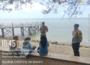 Personel Bhabinkamtibmas Polsek Bunguran Timur memberikan imbauan keselamatan dan warning kepada orang tua di tepi Pantai Piwang Natuna.