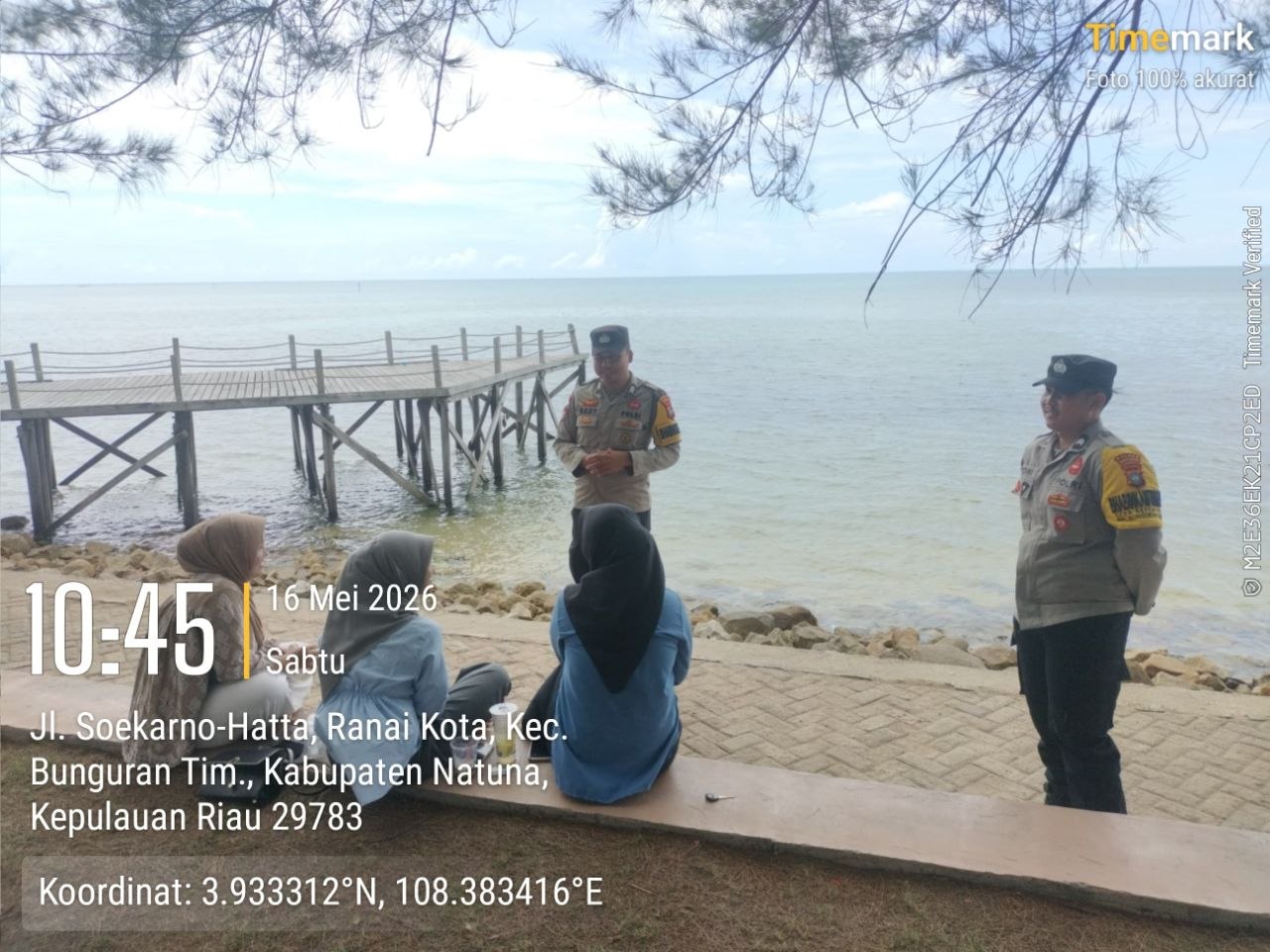 Personel Bhabinkamtibmas Polsek Bunguran Timur memberikan imbauan keselamatan dan warning kepada orang tua di tepi Pantai Piwang Natuna.