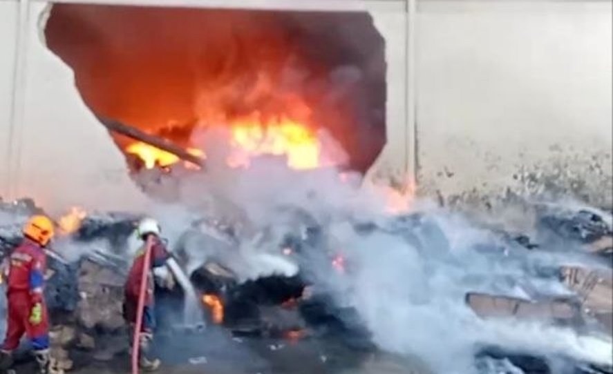 Petugas damkar berusaha memadamkan api yang membakar gudang pabrik di Citra Buana 3 Batam hingga dindingnya jebol