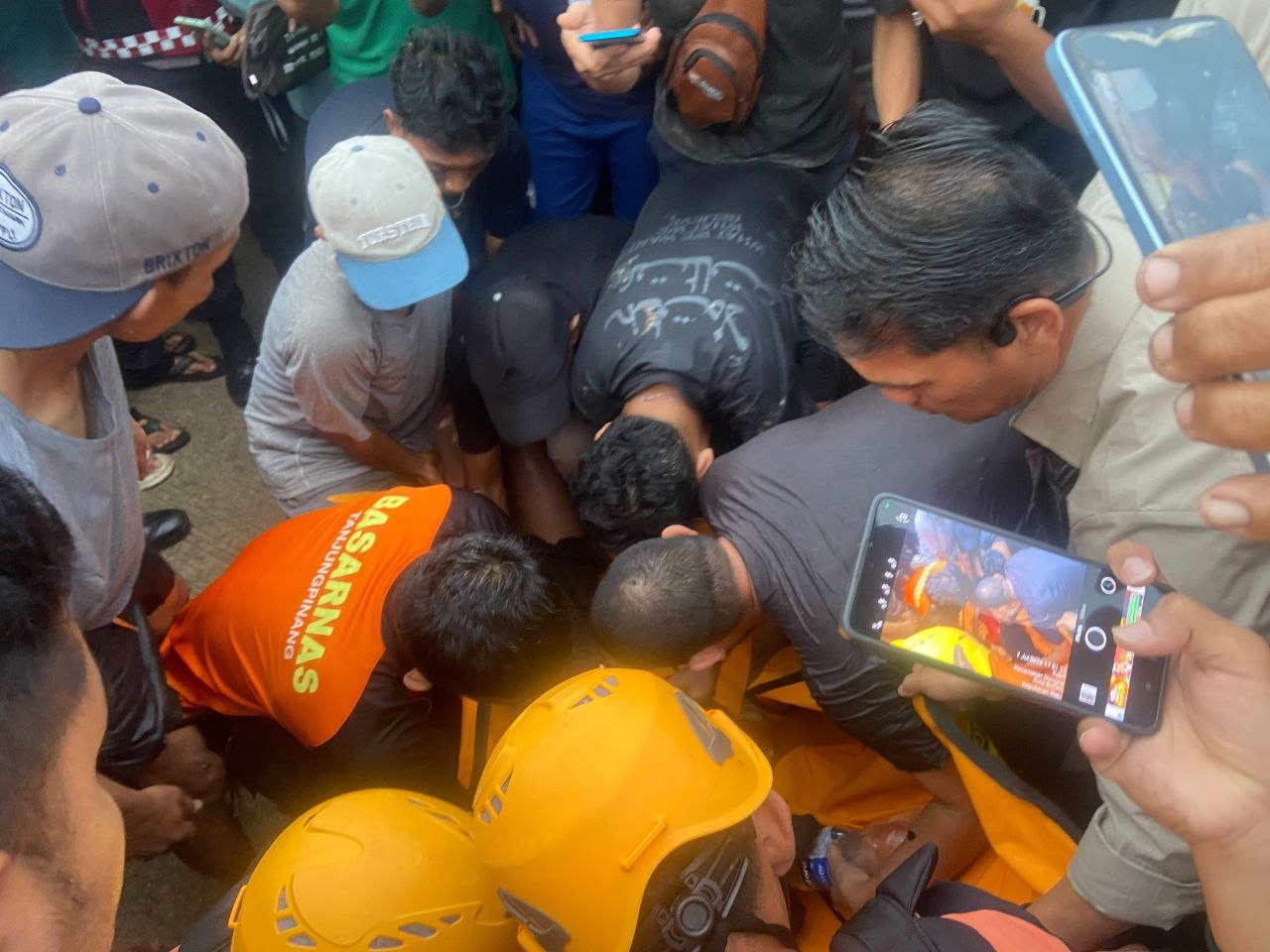Petugas gabungan saat mengevakuasi jasad siswa SMPN 63 Batam yang tewas terseret arus parit di Kabil.