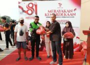 Direktur First Club Lian Tasrin secara simbolis menyerahkan paket kebutuhan pokok kepada pengemudi ojek online saat aksi sosial kemerdekaan.