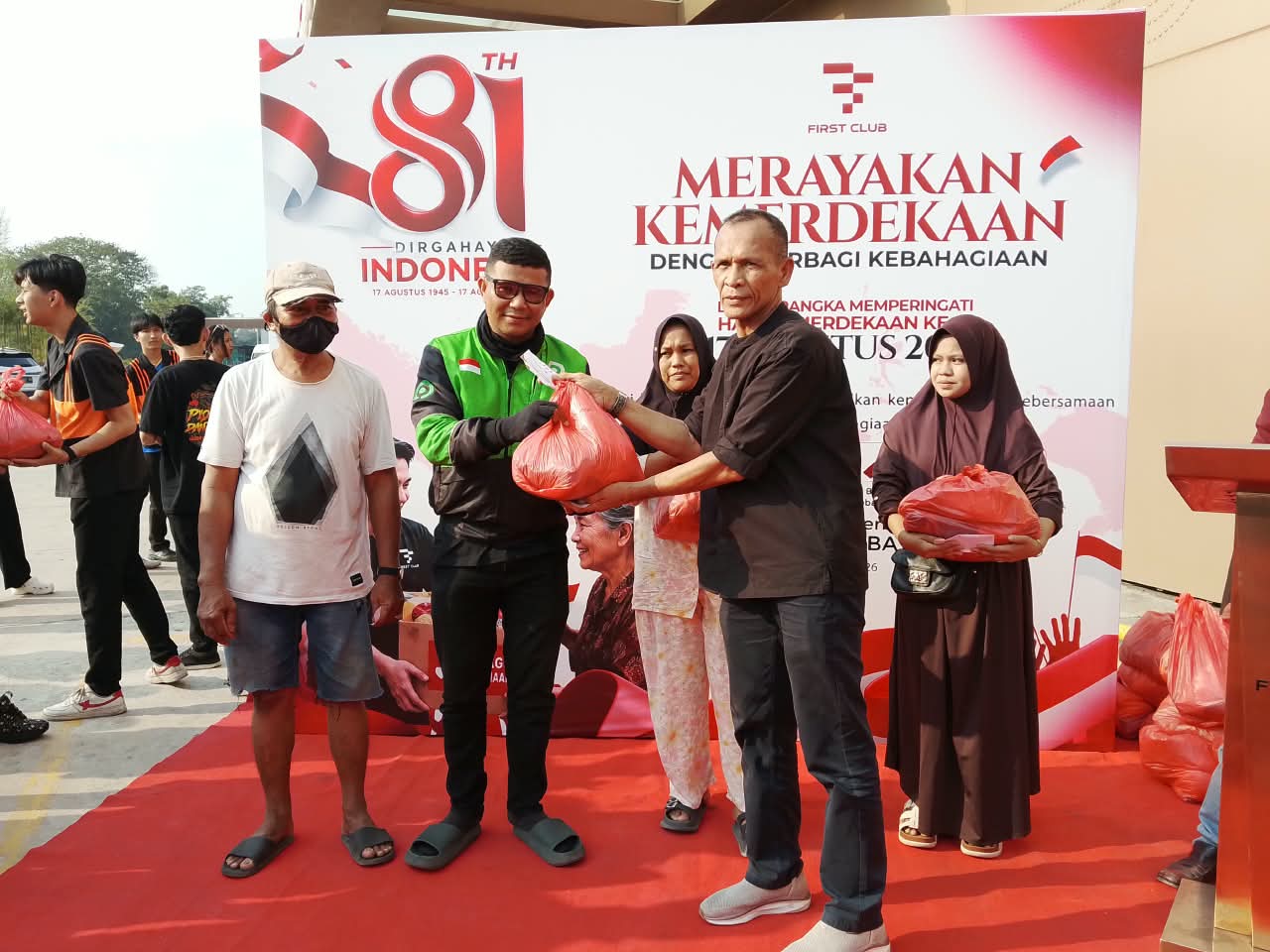 Direktur First Club Lian Tasrin secara simbolis menyerahkan paket kebutuhan pokok kepada pengemudi ojek online saat aksi sosial kemerdekaan.