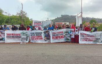 Warga Pulau Rempang membentangkan spanduk tuntutan ruang hidup saat mengheningkan cipta peringatan HUT RI ke-81 di Pantai Melayu.
