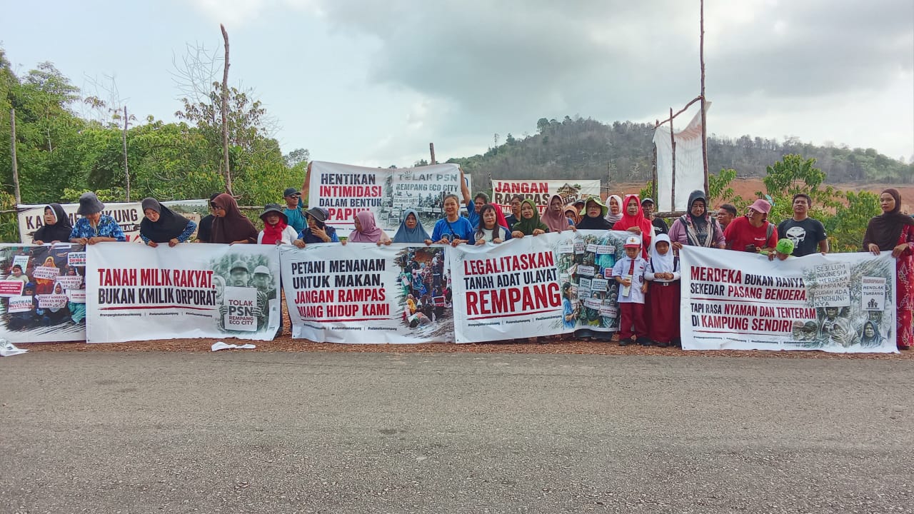 Warga Pulau Rempang membentangkan spanduk tuntutan ruang hidup saat mengheningkan cipta peringatan HUT RI ke-81 di Pantai Melayu.