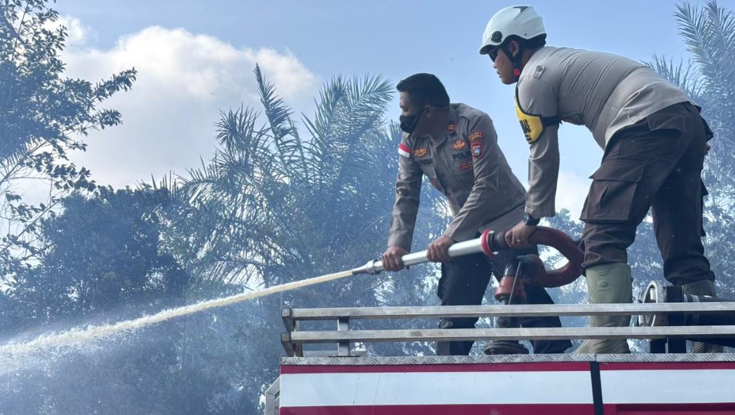 Petugas Damkar dan Polsek Bunguran Barat memadamkan kebakaran lahan di Bunguran Batubi Natuna.