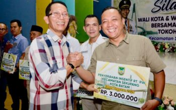 Wali Kota Batam, Amsakar Achmad, menyerahkan insentif saat menghadiri Silaturahmi bersama RT/RW, LPM, dan Tokoh Masyarakat se-Kecamatan Sekupang di Aula SMP Kartini Sei Harapan, Kecamatan Sekupang, Minggu (4/10/2026) malam.